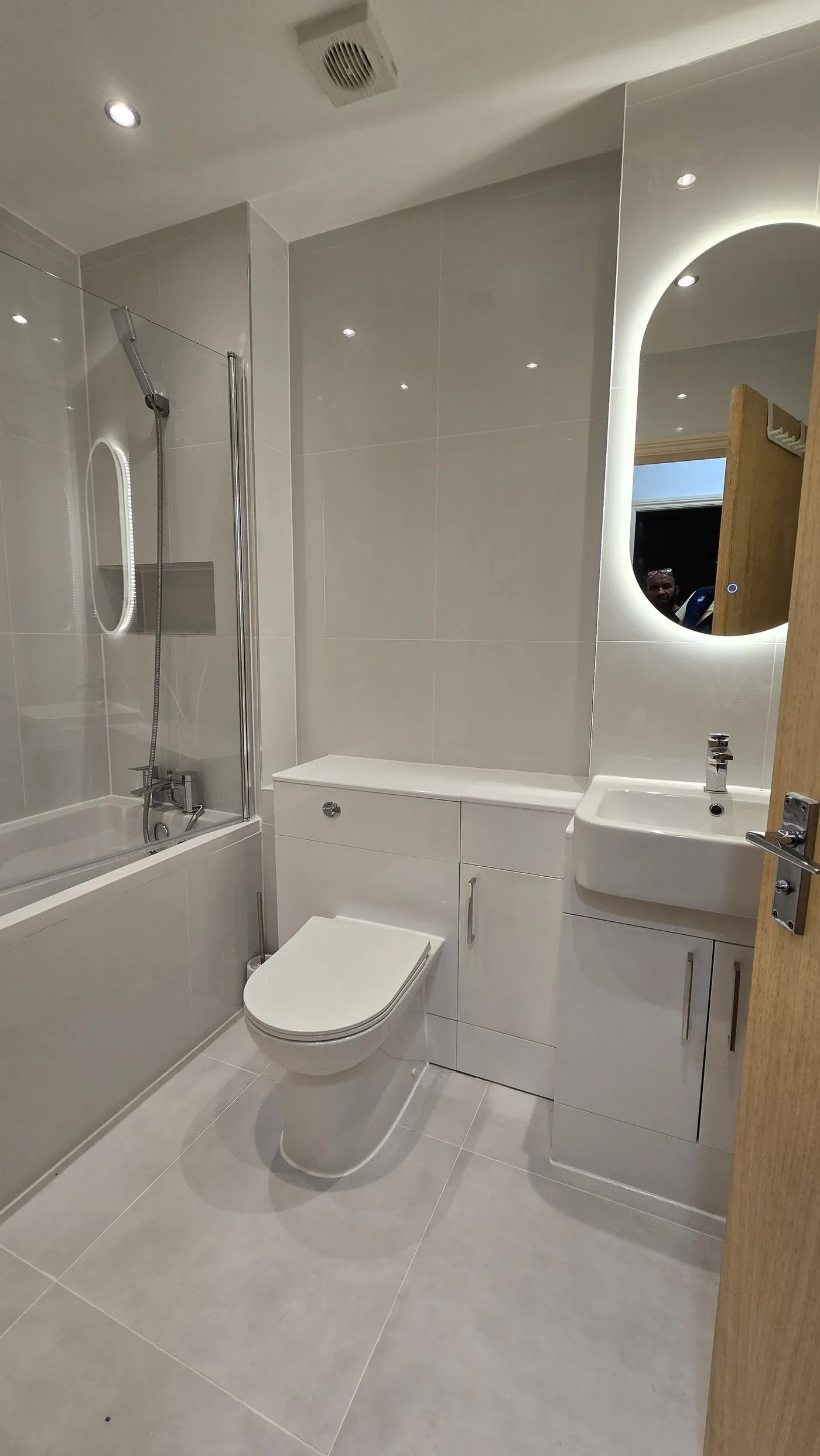 Finished bathroom with backlit mirror, London property refurbishment by Ferizi
